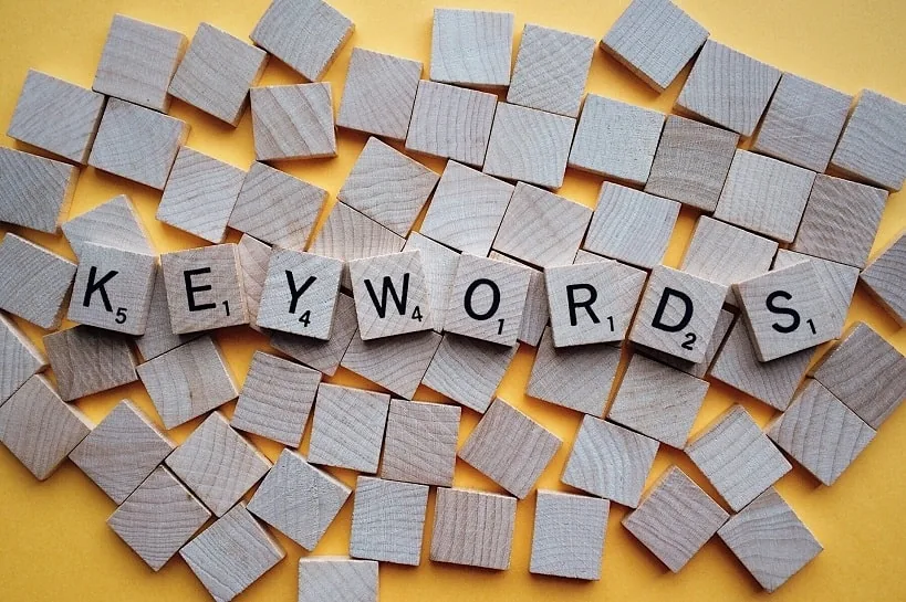 Деревянные фишки со скрабл-буквами складываются в слово KEYWORDS